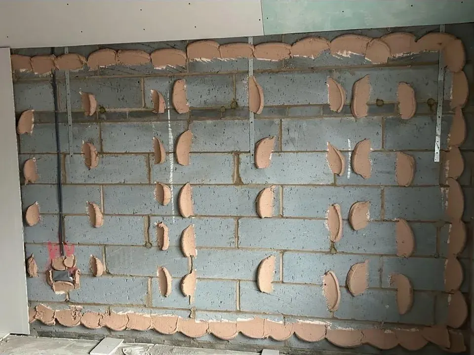Adhesive dabs to blockwork